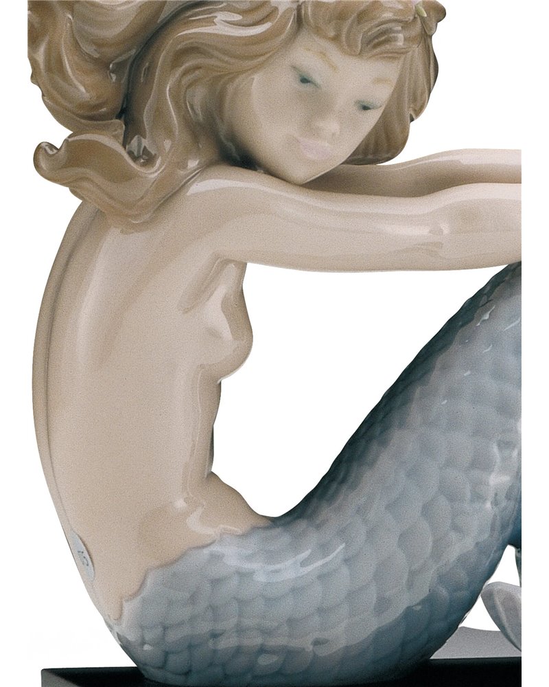 Sirena con brazos en las rodillas