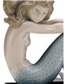 Sirena con brazos en las rodillas